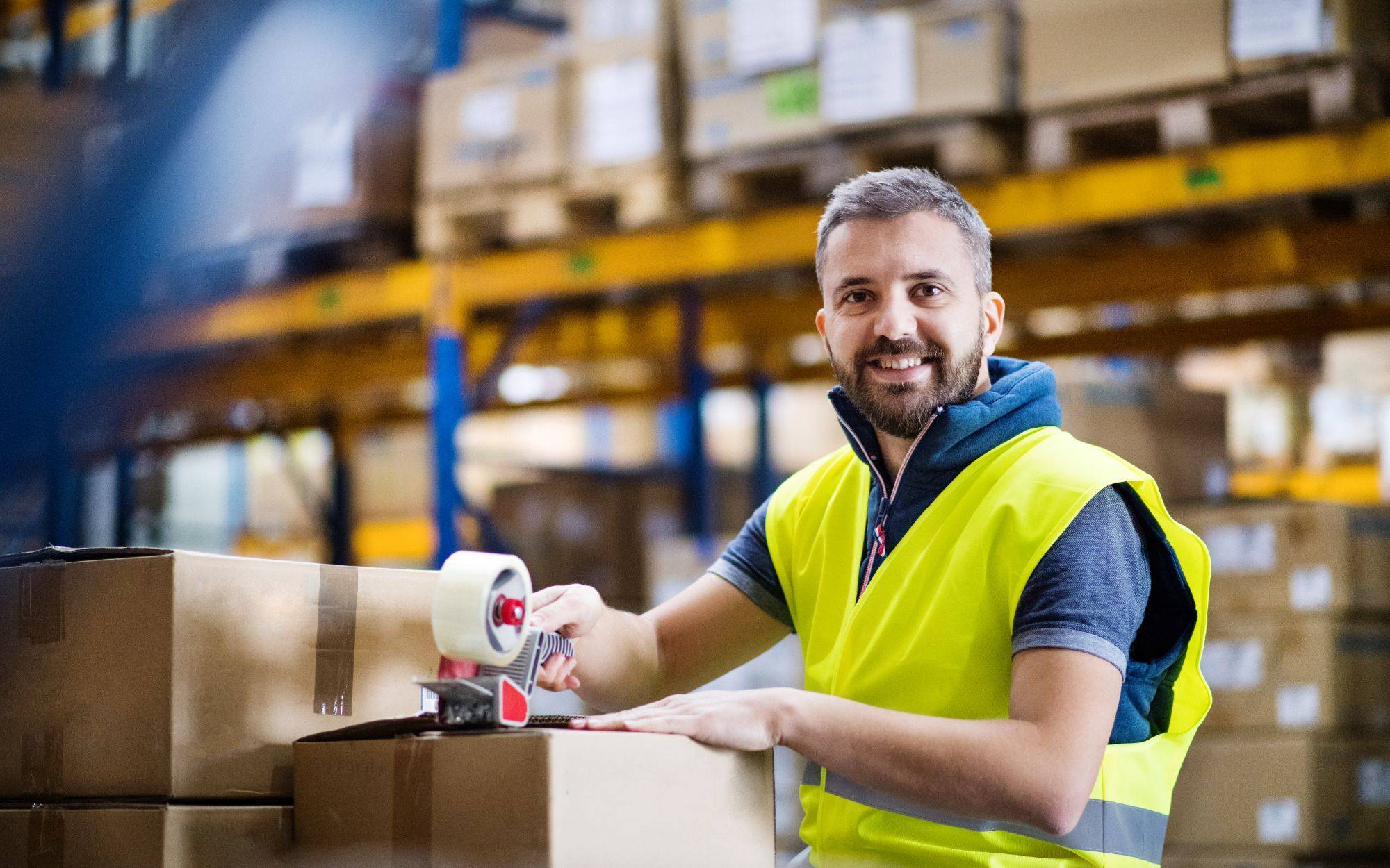 Male Warehouse Worker Sealing Boxes